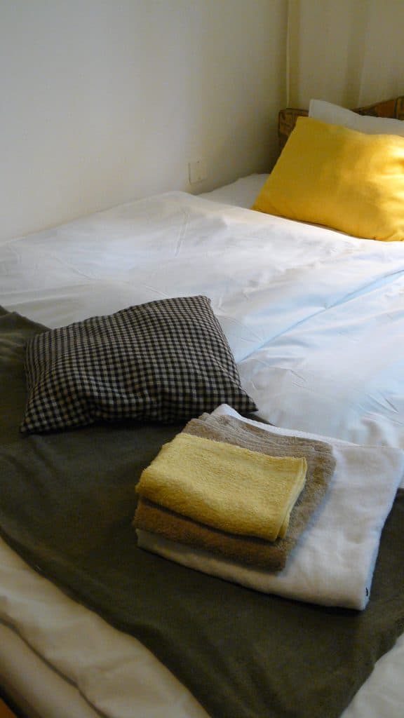 homestaging - postel so zltym vankusom a hnedou dekou